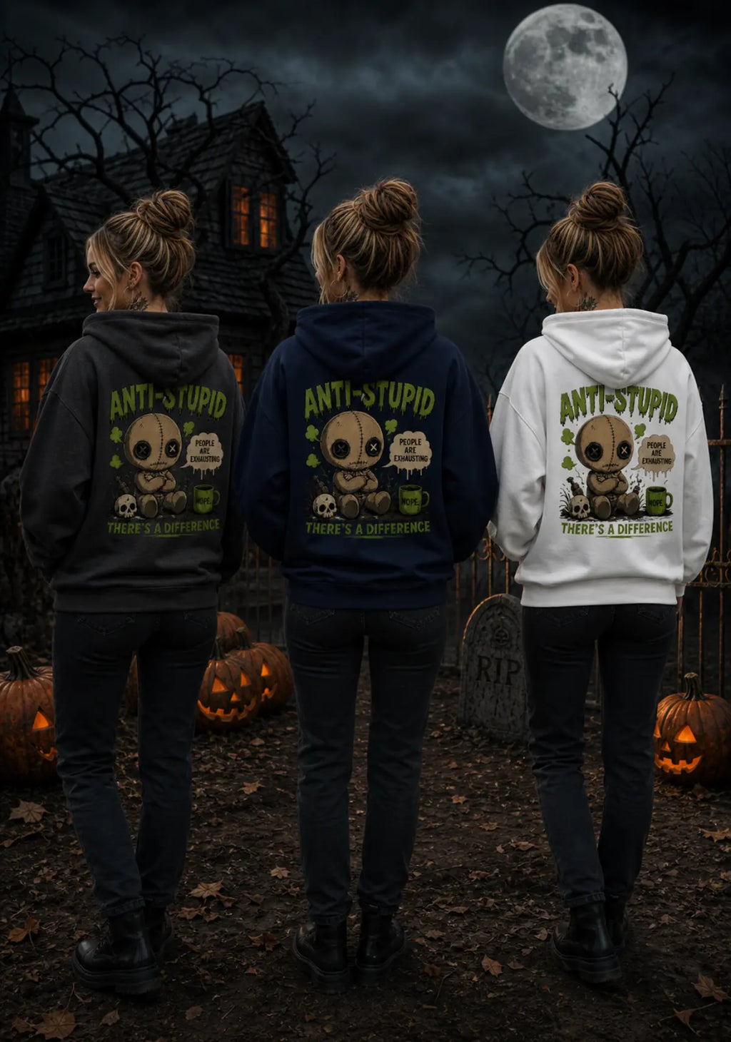 Three people wearing anti‑stupid voodoo doll hoodies in a spooky Halloween scene with a gothic house, full moon and glowing pumpkins