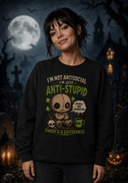 Woman in dark sweatshirt with chibi voodoo doll design and text “I’m not antisocial, I’m just anti‑stupid.”