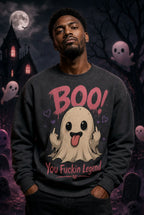 Person in dark sweatshirt with playful ghost graphic standing before haunted house backdrop with moon and floating cartoon ghosts