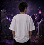 Person facing away in moonlit graveyard wearing white tee, standing amid tombstones, purple lantern glow and eerie misty atmosphere