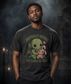 Person in dark gothic setting wearing a chibi Cthulhu tee, surrounded by stone arches, candles, and eerie atmospheric lighting.