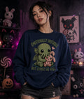 Emotionally unstable Cthulhu hugging a pink bunny on a navy sweatshirt, modeled indoors with plush toys and Halloween décor in the background.