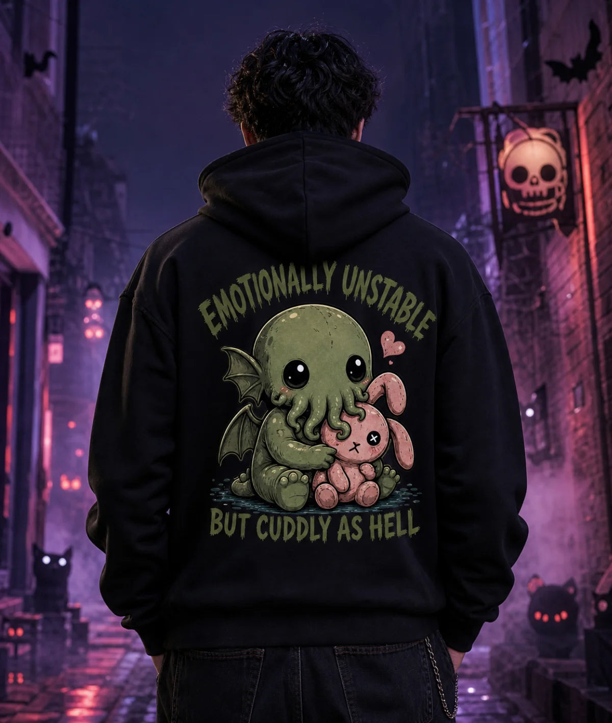 Person in black hoodie with chibi Cthulhu graphic standing in a moody alley lit by purple and blue eerie Halloween lighting.
