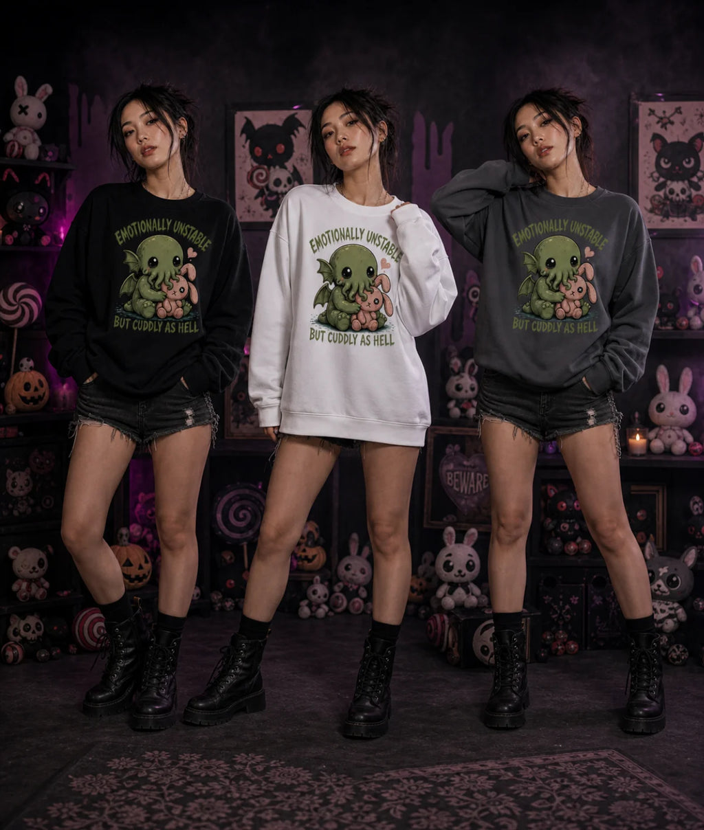 Three people in black, white, and gray Cthulhu sweatshirts standing indoors with gothic plush toys, pumpkins, and spooky décor.
