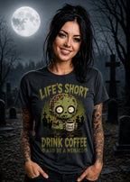 A woman stands in a moonlit graveyard wearing a black T‑shirt with a zombie graphic and “Life’s Short Drink Coffee” text.