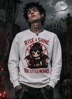 Person in gothic scene wearing chibi horror sweatshirt, standing before moonlit gates with bats and eerie atmospheric lighting