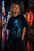 A woman stands on a wet neon‑lit city street wearing a dark navy graphic T‑shirt with a blue‑black fantasy character print and black pants.