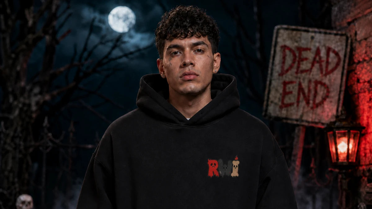 A man in a black RWI hoodie stands before a spooky “Dead End” sign, full moon, and eerie red lantern glow.