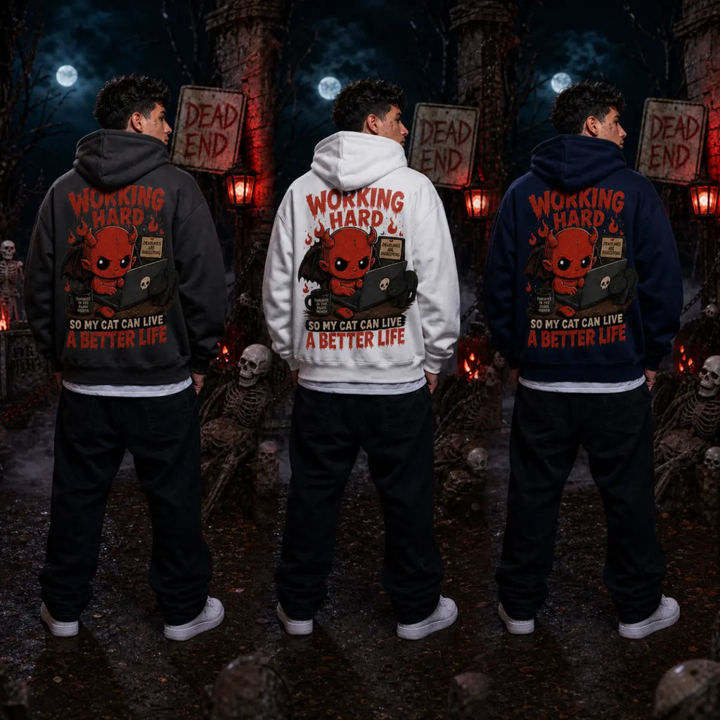 Three people wearing cat‑lover devil hoodies in a spooky graveyard scene with skeletons, tombstones, fog and red lantern light