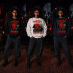 Three people wearing cat‑lover devil sweatshirts in a gothic room with red candles, skull décor and dark ornate furniture